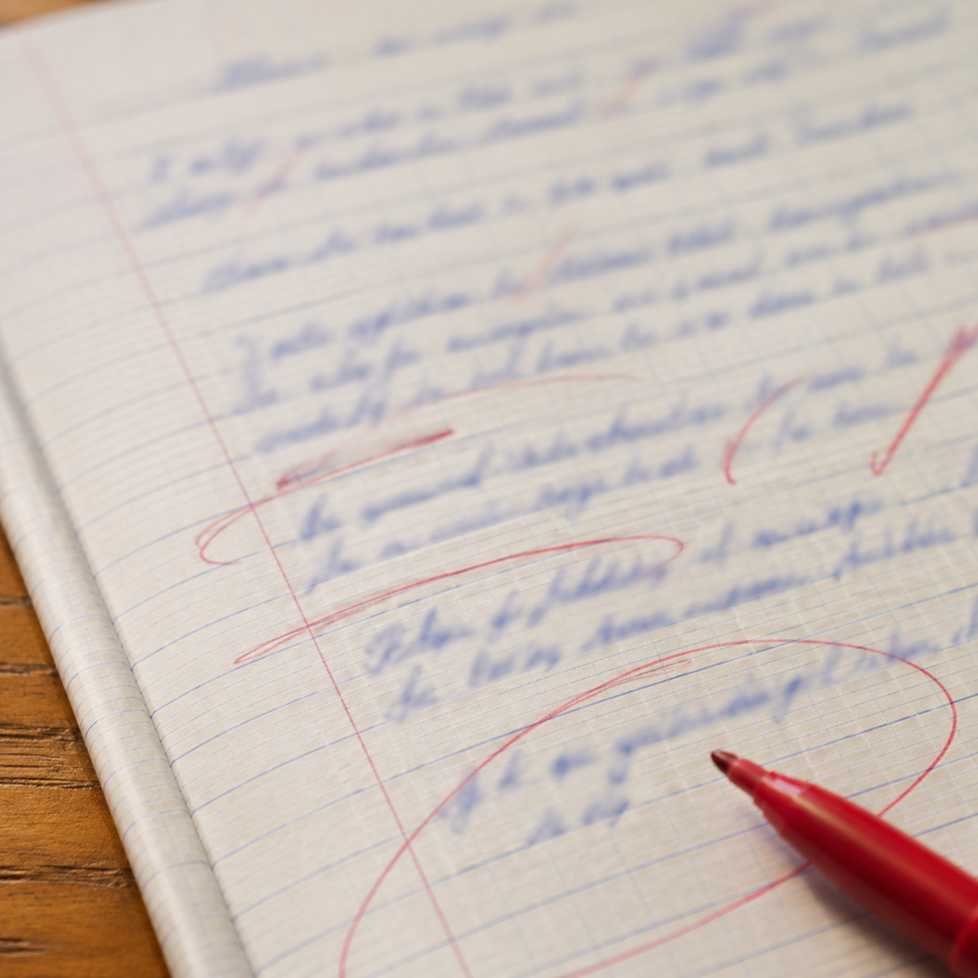 Annotations du stylo rouge sur copie à l'encre bleue, marques floues